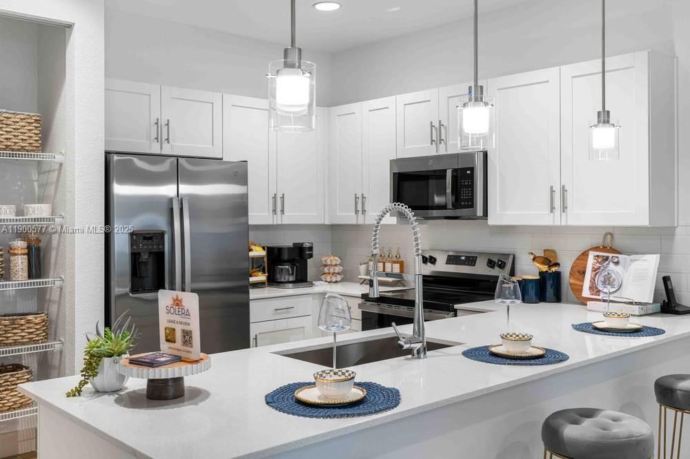 14502 Sloan Rdg Drive, Unit LUMINOSA Delray Beach, FL 33446 - Photo 29 of 49 a kitchen with stainless steel appliances granite countertop a sink and a refrigerator