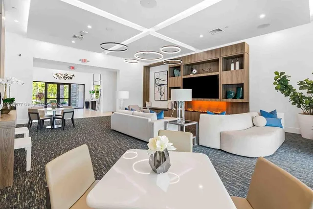 a living room with furniture kitchen view and a large window