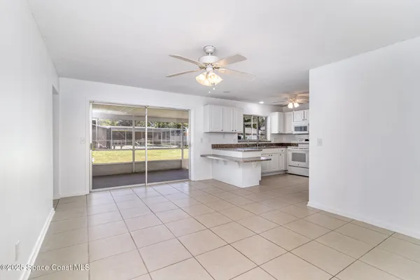 a kitchen with white cabinets and window