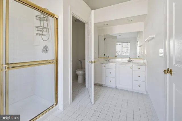 a spacious bathroom with a double vanity sink a mirror and a shower