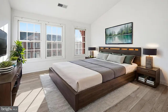 a bedroom with a large bed and a flat screen tv