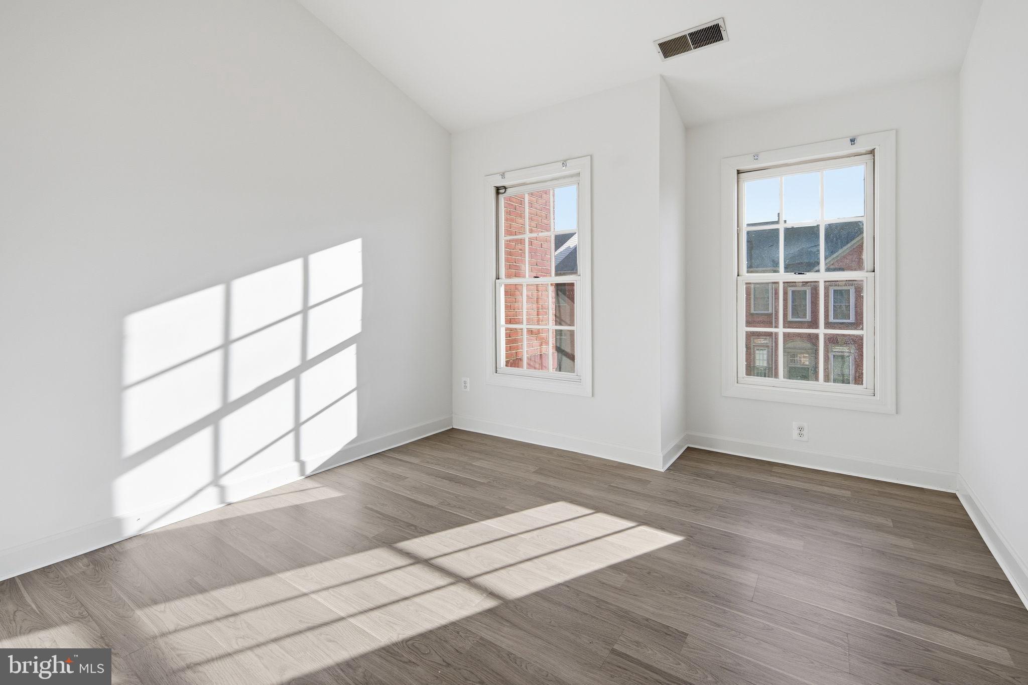 8026 Kidwell Hill Court Vienna, VA 22182 - Photo 15 of 22 an empty room with wooden floor and windows