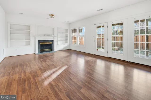 a view of empty room with wooden floor and fireplace