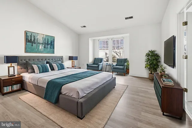 a spacious bedroom with a large bed and a flat screen tv