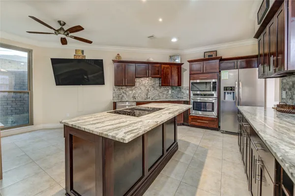a kitchen with stainless steel appliances kitchen island a stove a sink a refrigerator and a microwave