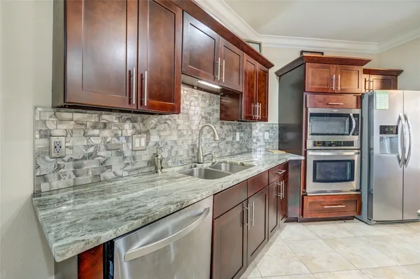 a kitchen with stainless steel appliances granite countertop a sink stove and refrigerator