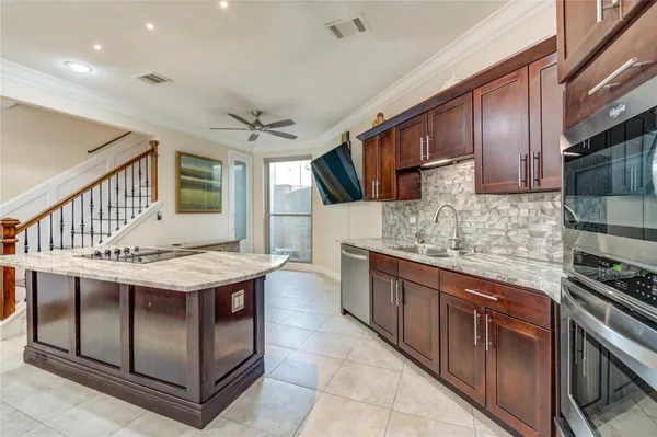 a kitchen with stainless steel appliances granite countertop a stove a sink dishwasher and a refrigerator