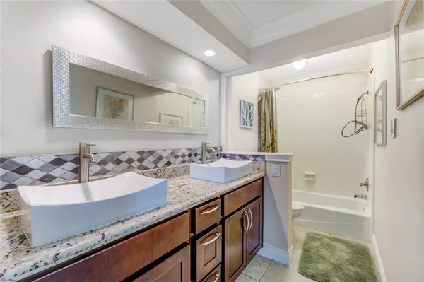 a bathroom with a granite countertop sink a mirror and a bathtub