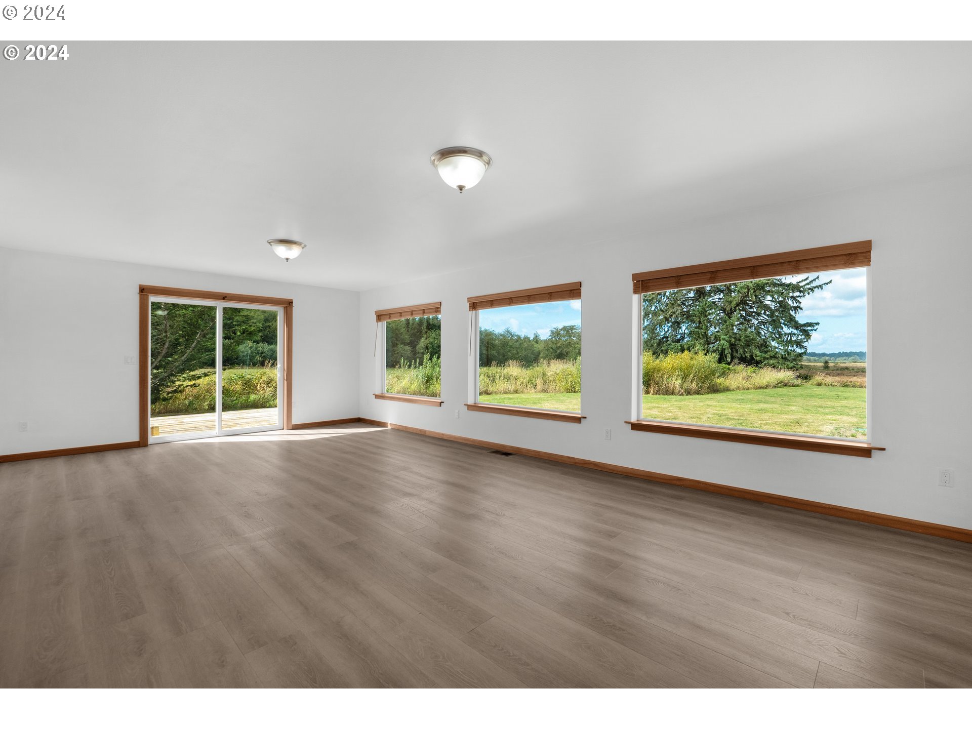 90713 Fort Clatsop Road Astoria, OR 97103 - Photo 6 of 30 an empty room with wooden floor and windows
