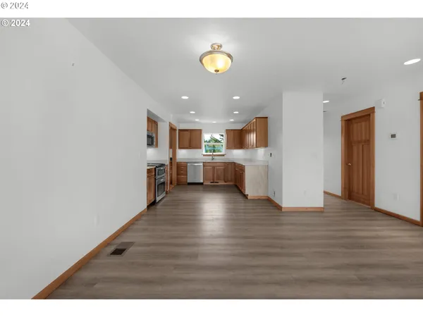 a view of kitchen and hall with wooden floor