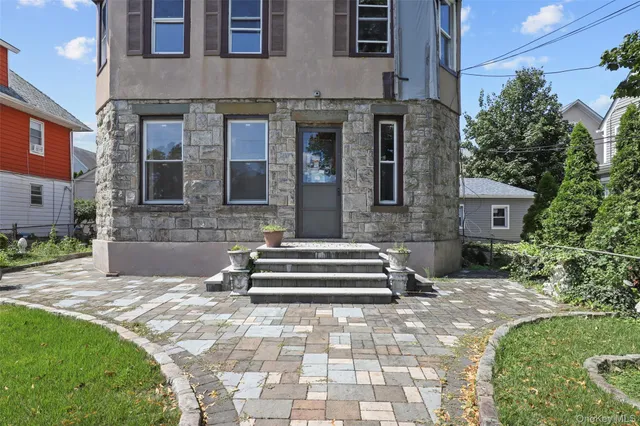 a front view of a house with a garden