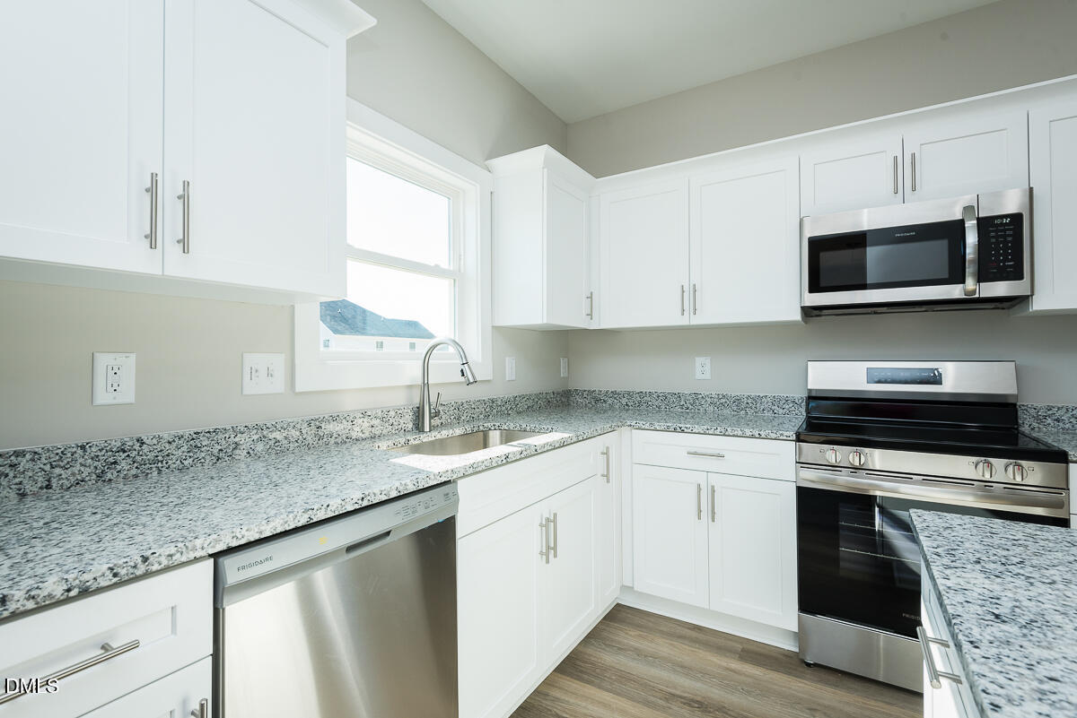 1125 Scarlet Oak Rd Spring Spring Hope, NC 27882 - Photo 9 of 29 a kitchen with stainless steel appliances granite countertop a sink dishwasher a stove and a microwave oven with cabinets
