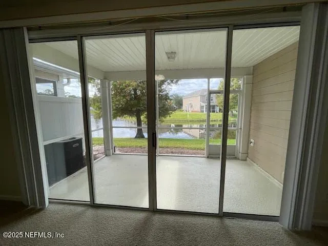 a view of an empty room with floor to ceiling windows with wooden floor