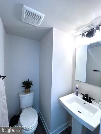 a kitchen with a sink stove and wooden floor