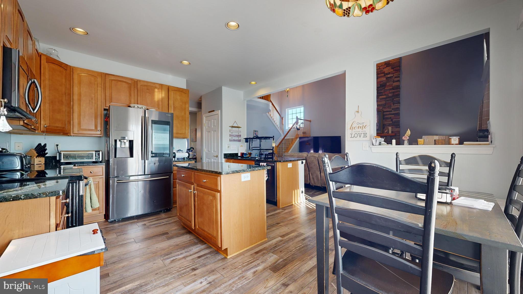 24875 Rivers Edge Road Millsboro, DE 19966 - Photo 11 of 48 a kitchen with stainless steel appliances kitchen island granite countertop a refrigerator stove and sink