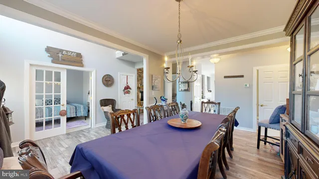 a view of a dining room and livingroom with furniture wooden floor a chandelier
