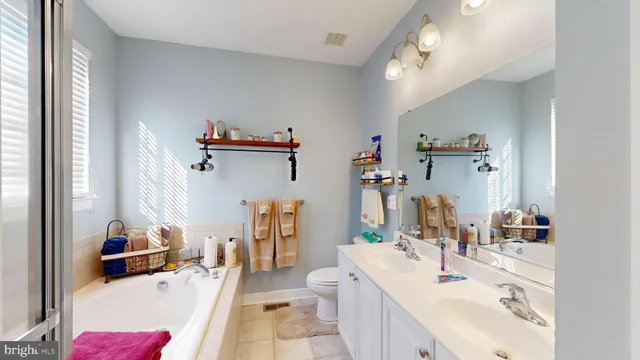 a bathroom with a sink vanity granite tub and shower