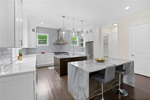 a kitchen with stainless steel appliances granite countertop a sink stove and cabinets