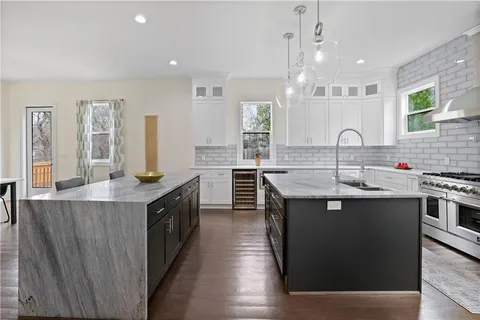 a kitchen with stainless steel appliances a stove and white cabinets