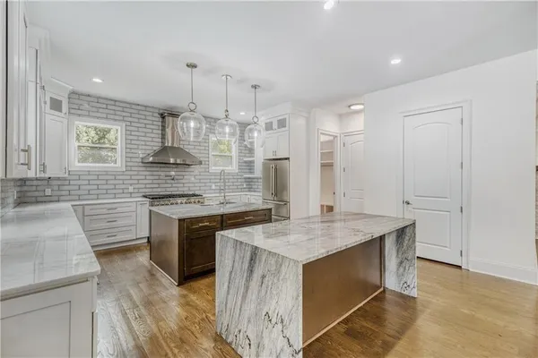 a bathroom with a granite countertop sink toilet and a bathtub