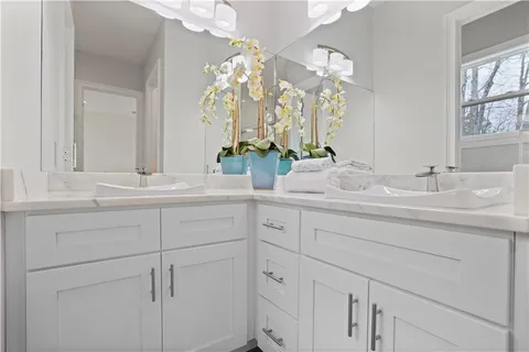 a spacious bedroom with a bed a couch and a chandelier