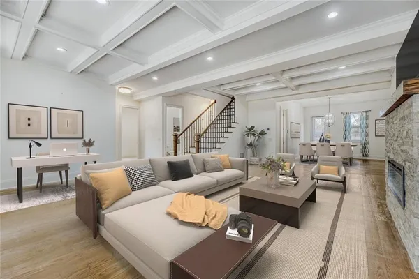 an empty room with wooden floor and a kitchen