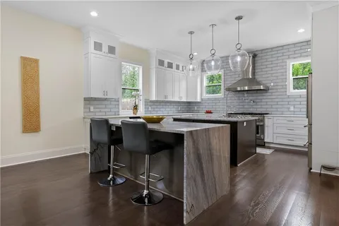 a kitchen with kitchen island granite countertop a sink a counter space appliances and cabinets