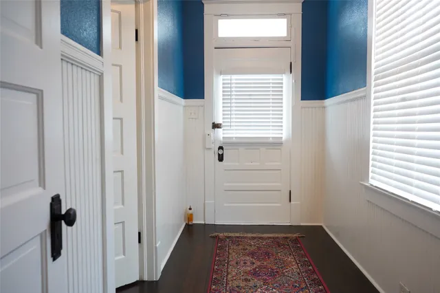 a view of a hallway with wooden floor and a window