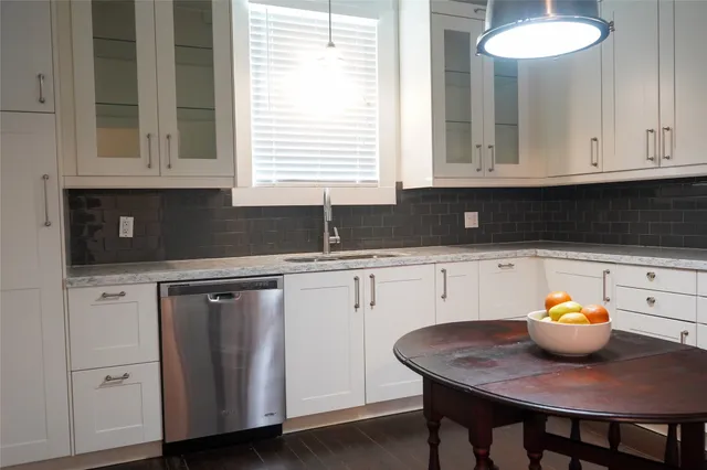 a kitchen with stainless steel appliances granite countertop a sink and a white cabinets