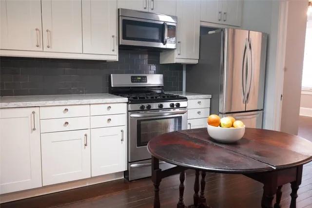a kitchen with a sink a stove and white cabinets