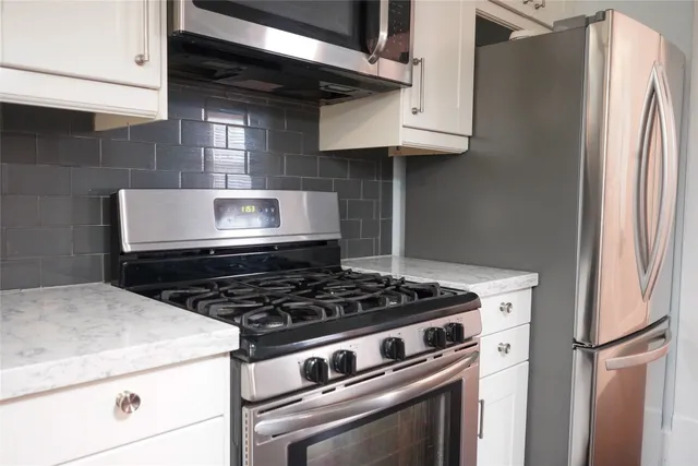 a stove top oven sitting inside of a kitchen