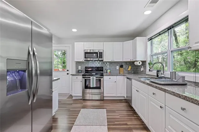 a kitchen with stainless steel appliances granite countertop a refrigerator sink and stove