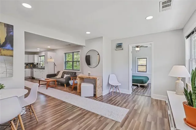 a living room with furniture a table and wooden floor