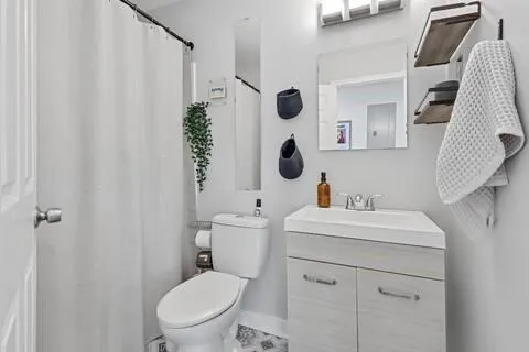 a bathroom with a sink a toilet and shower