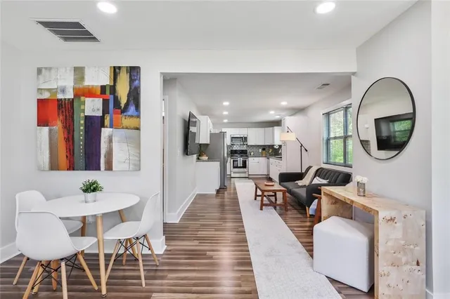 a living room with furniture a rug and kitchen view