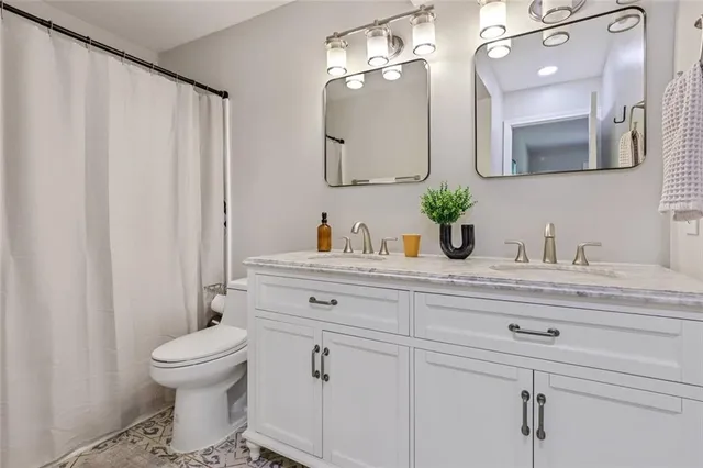 a bathroom with a toilet a sink and mirror