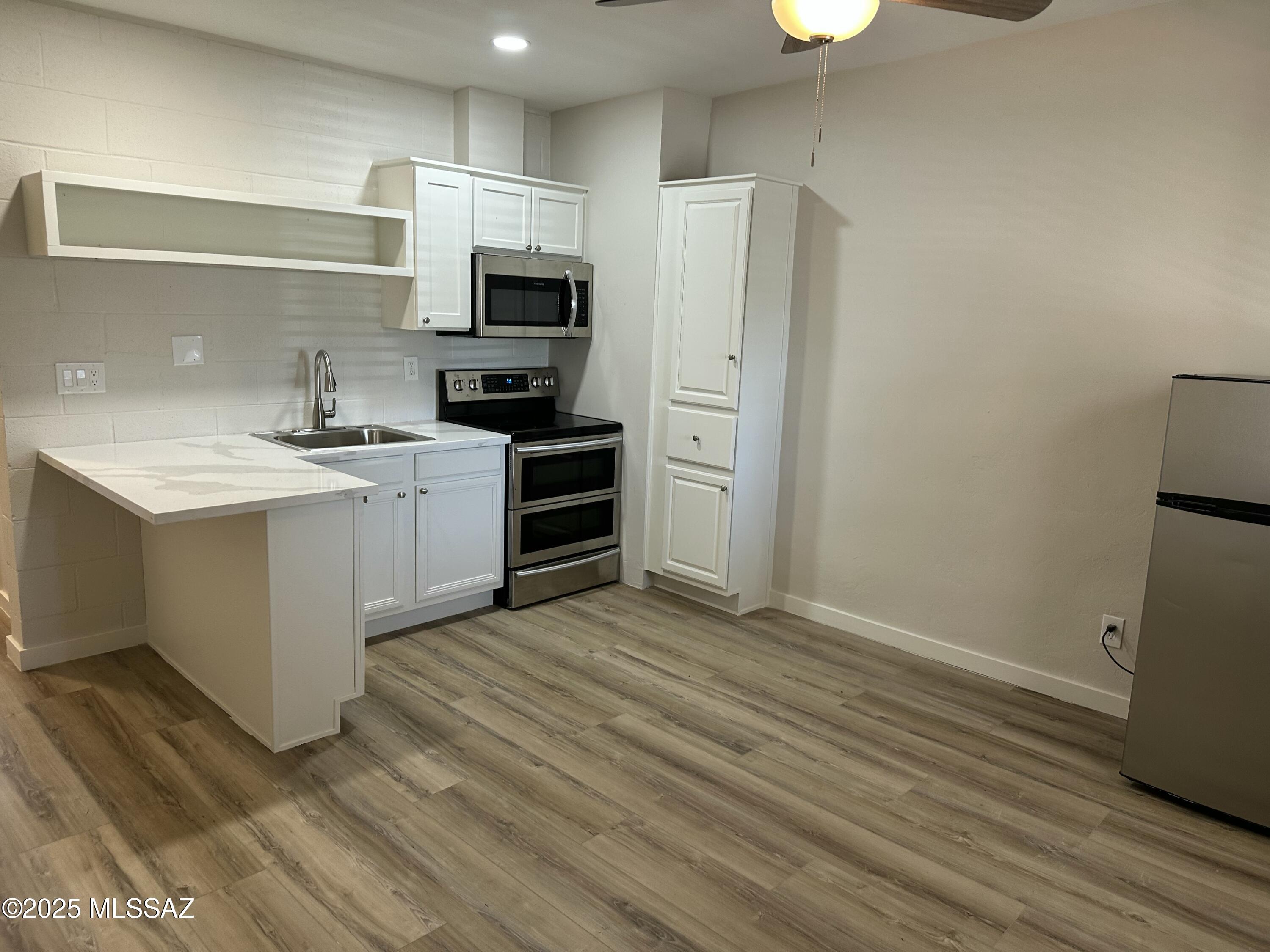 645 East Mabel Street Tucson, AZ 85705 - Photo 17 of 22 a kitchen with stainless steel appliances a sink cabinets and wooden floor