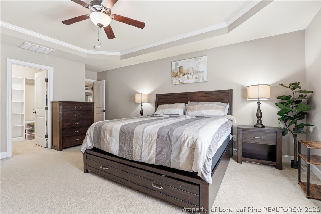 886 Micahs Way North Spring Lake, NC 28390 - Photo 20 of 50 a spacious bedroom with a bed and a chandelier