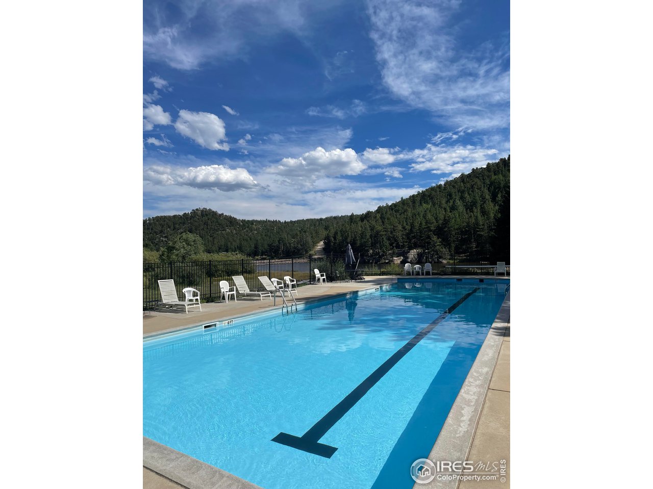 0 Hemlock Drive Lyons, CO 80540 - Photo 26 of 30 a view of a patio with dining table and chairs with a floor to ceiling window
