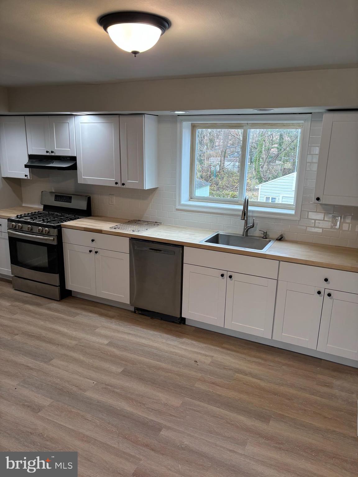 1948 Carter Road Folcroft, PA 19032 - Photo 4 of 8 a white kitchen with granite countertop stainless steel appliances a stove sink and cabinets