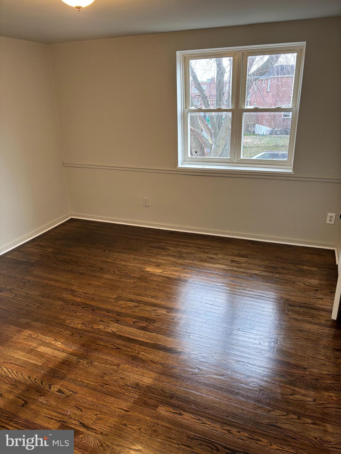 1948 Carter Road Folcroft, PA 19032 - Photo 5 of 8 an empty room with wooden floor and windows