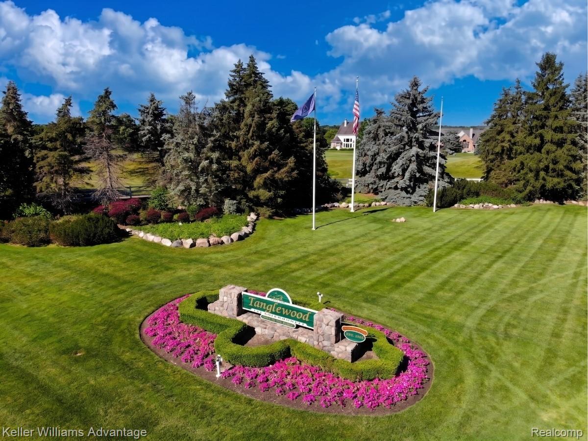 22878 Tree Top Court South Lyon, MI 48178 - Photo 65 of 75 Stone monument sign with "Tanglewood" inscription, surrounded by manicured green lawn and colorful ground cover
