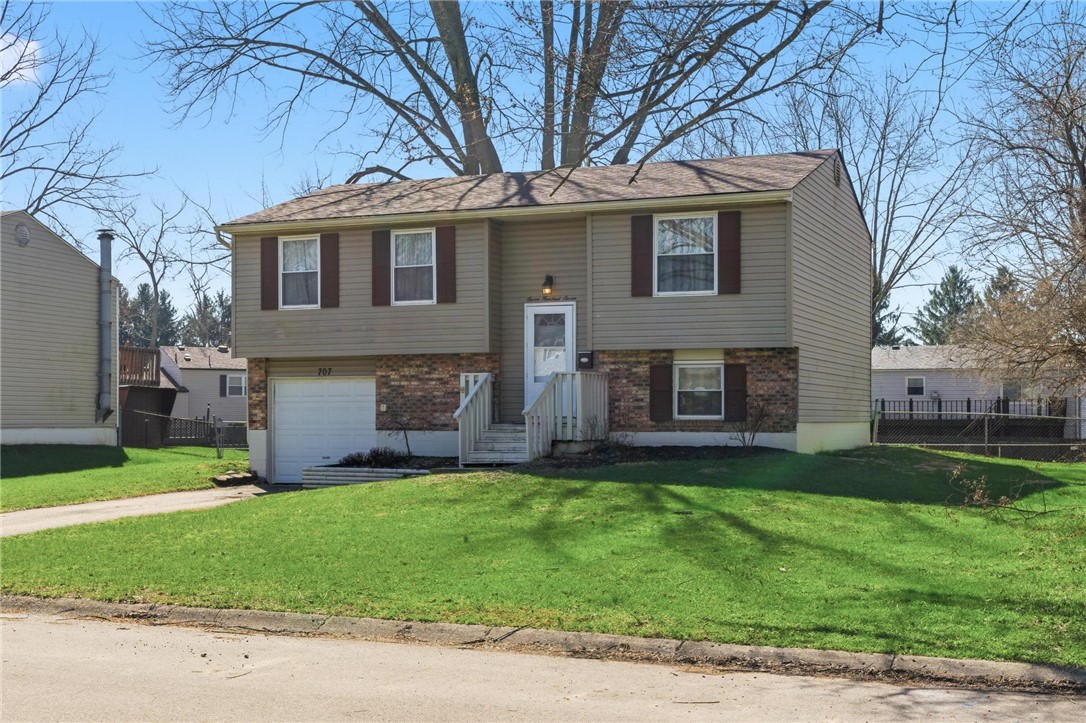 707 West Martindale Road Union, OH 45322 - Photo 23 of 28 This classic split-level home offers a welcoming facade with a garage and a well-maintained lawn.
