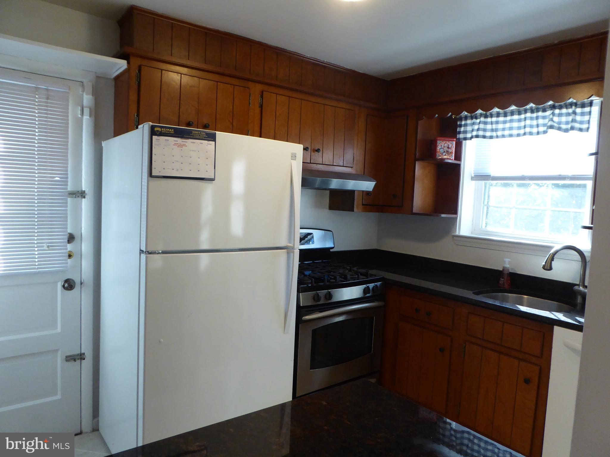 12820 Crisfield Road Silver Spring, MD 20906 - Photo 11 of 24 a white refrigerator freezer sitting in a kitchen