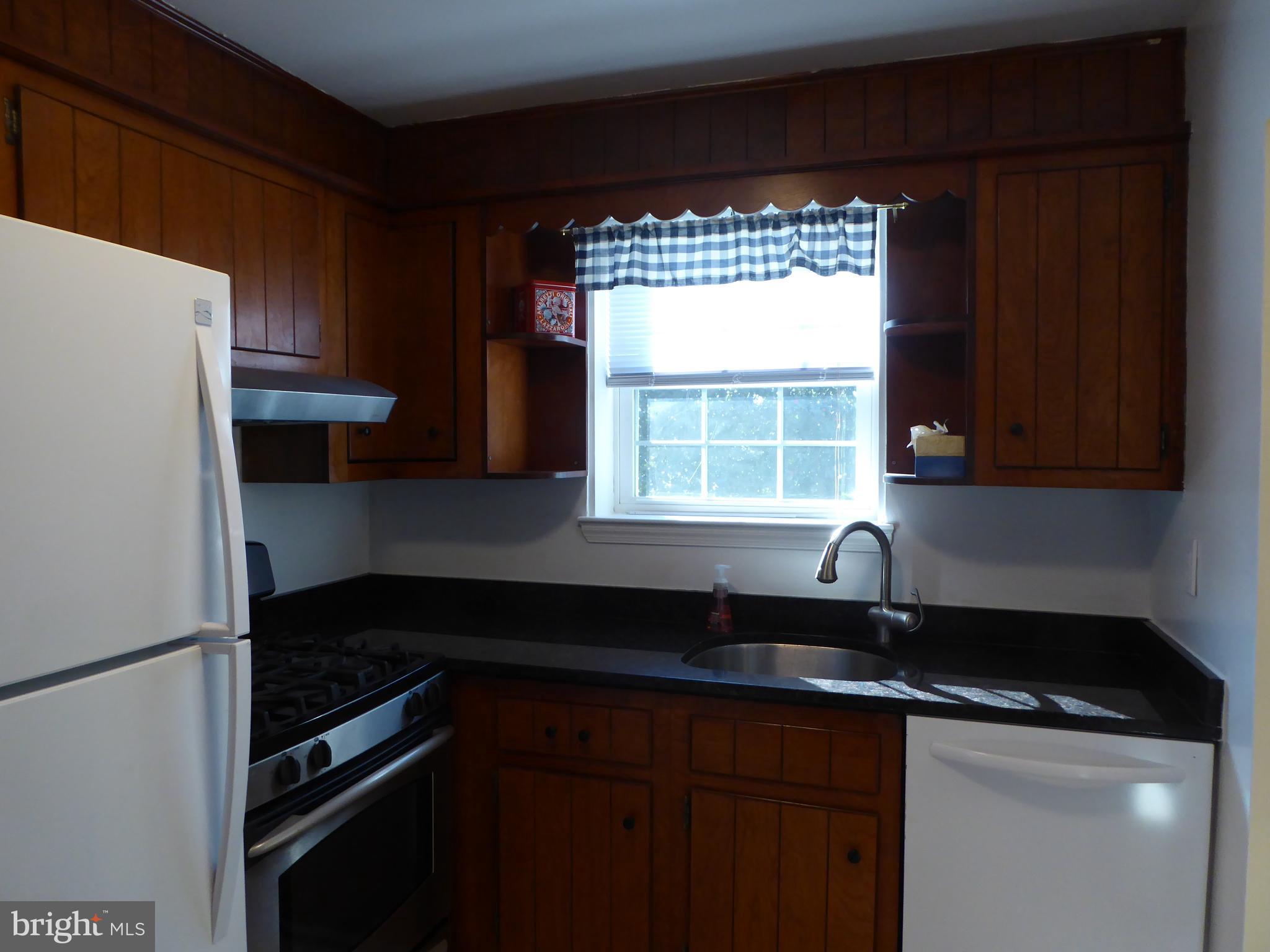 12820 Crisfield Road Silver Spring, MD 20906 - Photo 13 of 24 a kitchen with a sink a refrigerator and cabinets