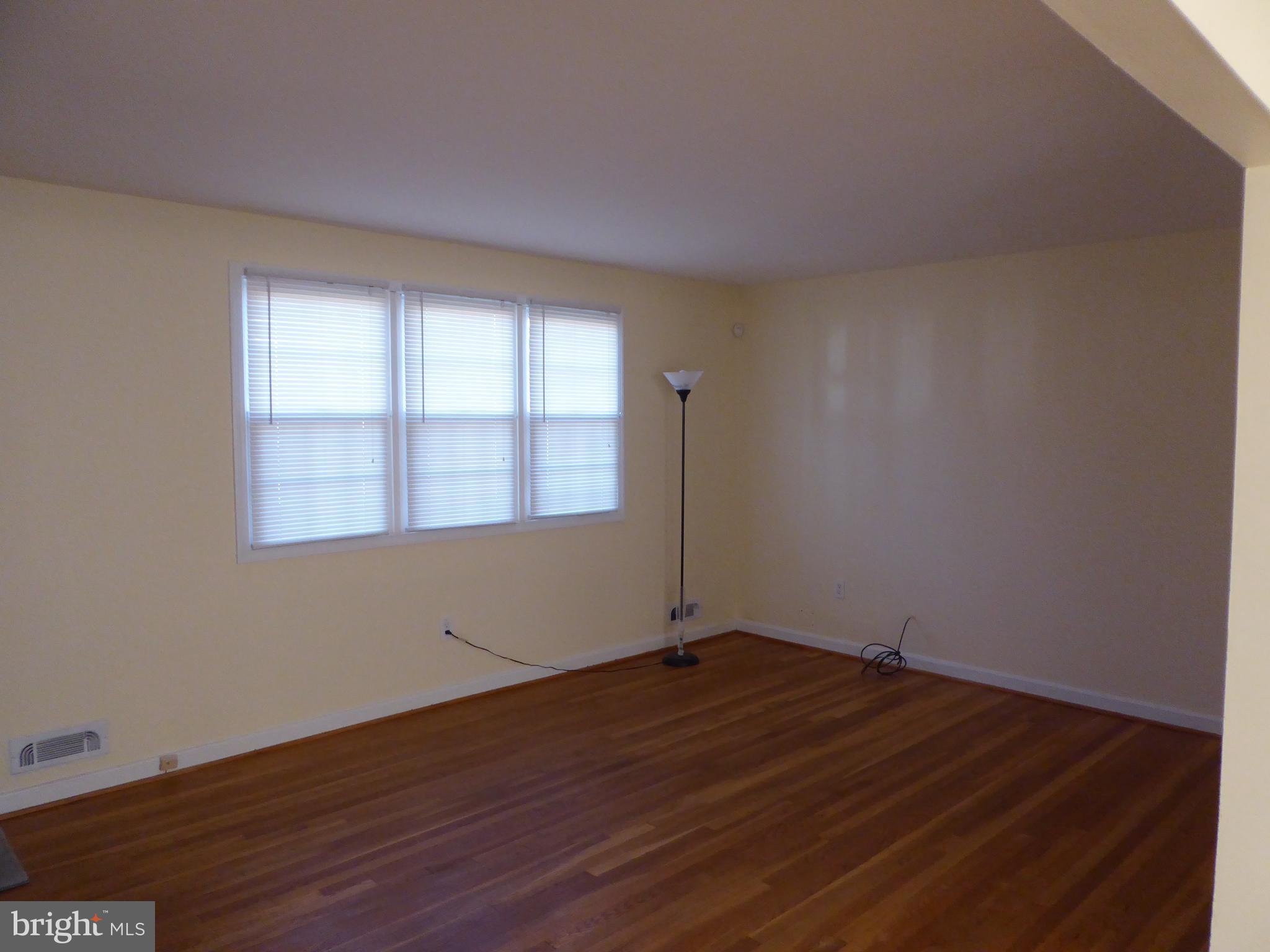 12820 Crisfield Road Silver Spring, MD 20906 - Photo 7 of 24 a view of an empty room with wooden floor and a window