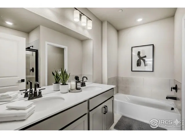 a bathroom with a tub a sink and mirror