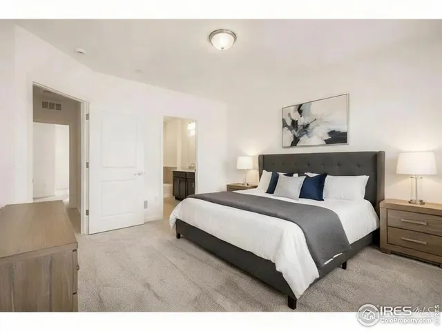 a bedroom with a bed and a painting on the wall