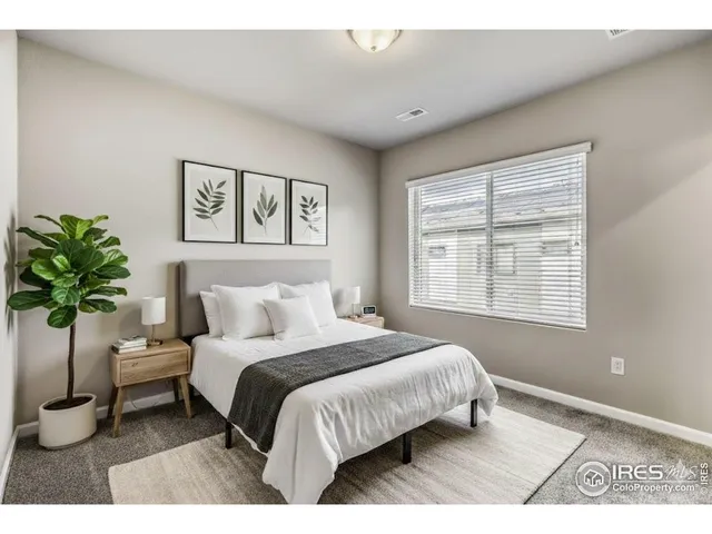 a bedroom with a large bed and a potted plant