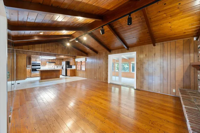 a large kitchen with stainless steel appliances kitchen island granite countertop a sink and wooden cabinets